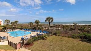 Ein Poolbereich mit Blick auf Strand und Meer.