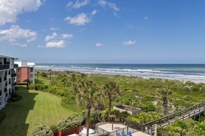 A view of a beachside property with a patio, a pool, and a view of the ocean. - Barefoot Trace 409 Direct Oceanfront with Private Balcony Overlooking St. Augustine Beach (St. Augustine)