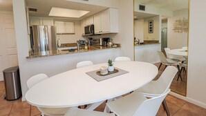 Een moderne keuken met witte kasten, roestvrijstalen apparatuur en een granieten aanrecht.