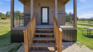 A wooden staircase leading to a porch with a sign reading 'HUC TERRY INN.' - Huckleberry Inn - 1 BD Cabin (Custer)