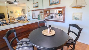 A dining area with a round table, black chairs, and a wooden board with condiments. - St Augustine Beach & Tennis Resort 611-Pet-Friendly Townhome! (St. Augustine)