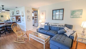 A living room with a blue sofa, wooden rocking chair, and a glass coffee table. - St Augustine Beach & Tennis Resort 611-Pet-Friendly Townhome! (St. Augustine)