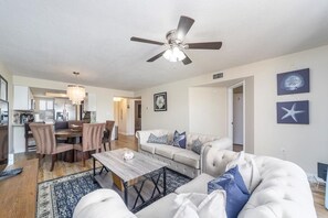 A modern living room with a sofa, coffee table, and dining area. - Ocean Village Club K34 (St. Augustine)