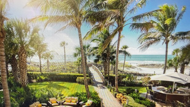 A tropical outdoor area with a fire pit, seating, and a view of the beach. - Hyatt Resort Siesta Key July 4th 3br/3ba 2255sqft Balcony over beach! Sleeps 6/8 (Sarasota)