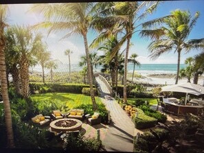 Un espace extérieur de style tropical, doté d’un foyer, de sièges et offrant une vue sur la plage.