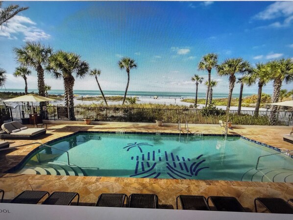 A pool area with lounge chairs, a palm tree-lined deck, and a view of the beach. - Hyatt Resort Siesta Key July 4th 3br/3ba 2255sqft Balcony over beach! Sleeps 6/8 (Sarasota)