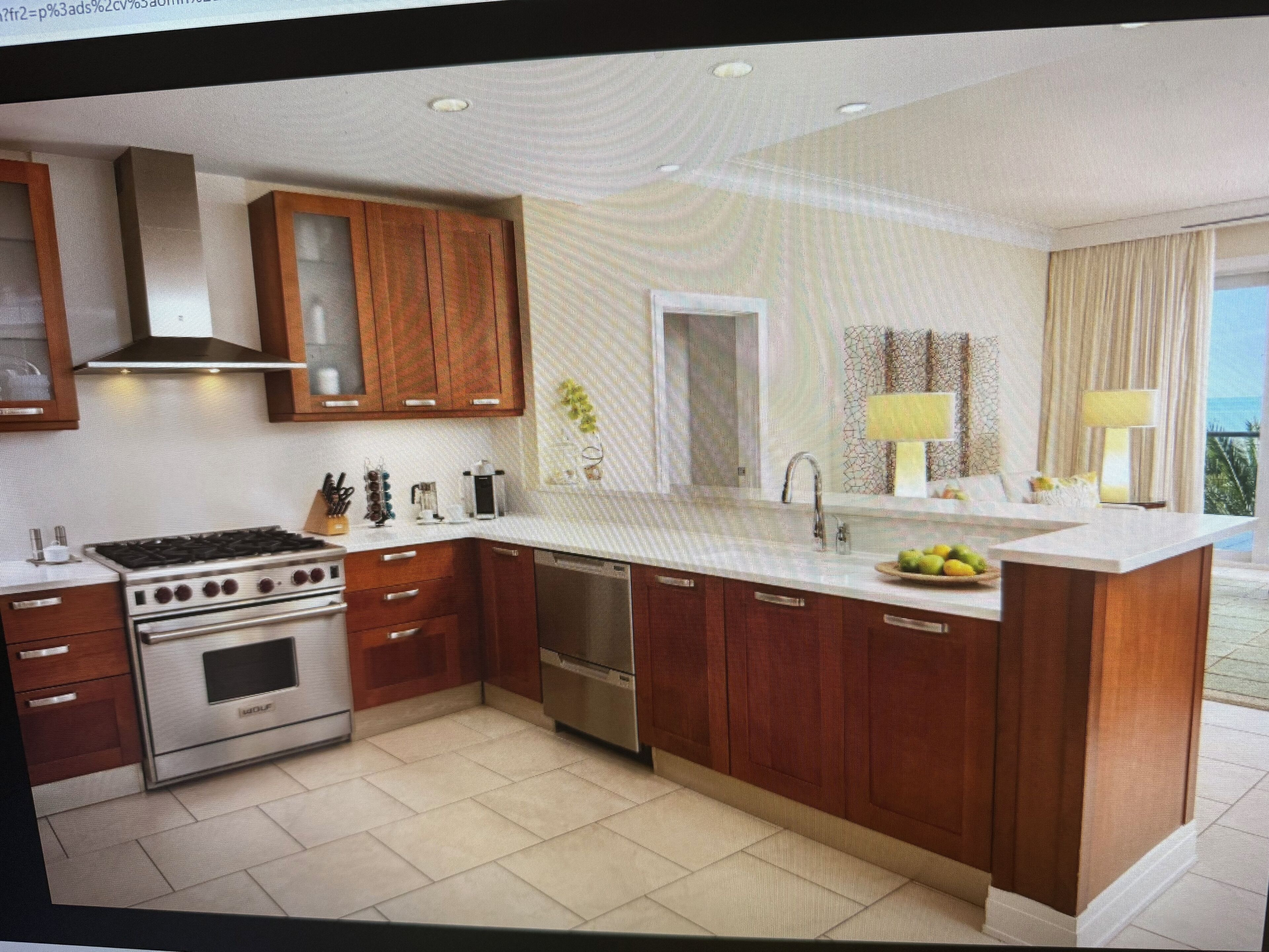 A modern kitchen with wooden cabinets, stainless steel appliances, and a large island with a sink and fruit bowl.