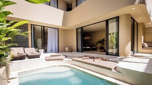 Un área de piscina moderna al aire libre con sillones de descanso y un jacuzzi.