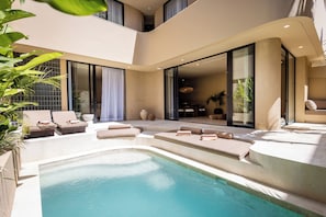 A modern outdoor pool area with lounge chairs and a hot tub. - SISI Wellness Villas (Pecatu)