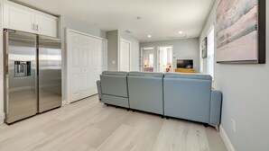 A modern kitchen with a built-in refrigerator and a grey sofa in the living area. - 4 Mi to Downtown Tampa! Urban Couples Retreat (Tampa)