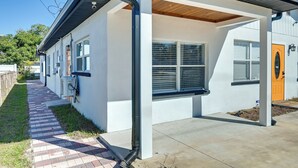 A modern house with a covered porch, a brick pathway, and a well-maintained lawn. - 4 Mi to Downtown Tampa! Urban Couples Retreat (Tampa)
