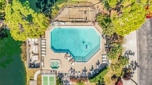 An octagonal swimming pool with a deck, surrounded by palm trees and a tennis court. - Tranquil Sarasota Retreat Near Beaches, Pool & Nature Escape - Timberwood Villa #183 - Roelens (Sarasota)