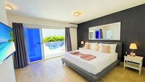 Habitación de hotel moderna con una cama grande, televisión, puerta corredera de cristal a un área de piscina y una pared de color oscuro.
