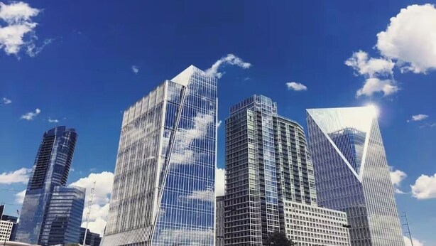 Une vue urbaine avec des gratte-ciel modernes sous un ciel bleu dégagé.