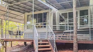 Un espace extérieur abrité, doté d’un escalier menant à un bâtiment avec de grandes fenêtres.