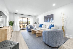 A modern living room with a sofa, coffee table, and a TV on a wooden stand.