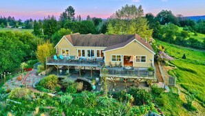 A two-story house with a deck and outdoor seating area. - Hummingway Ranch, by Vinifera Homes (Forestville)