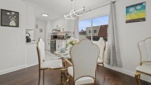 A dining area with a round table, white chairs, and a modern pendant light. - Luxury3bCondo DTAlhambra Near Starbucks, Pasadena, DTLA Free 2parking. (Alhambra)