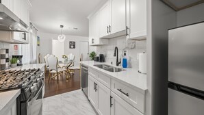 A modern kitchen with white cabinets, stainless steel appliances, and a marble countertop. - Luxury3bCondo DTAlhambra Near Starbucks, Pasadena, DTLA Free 2parking. (Alhambra)