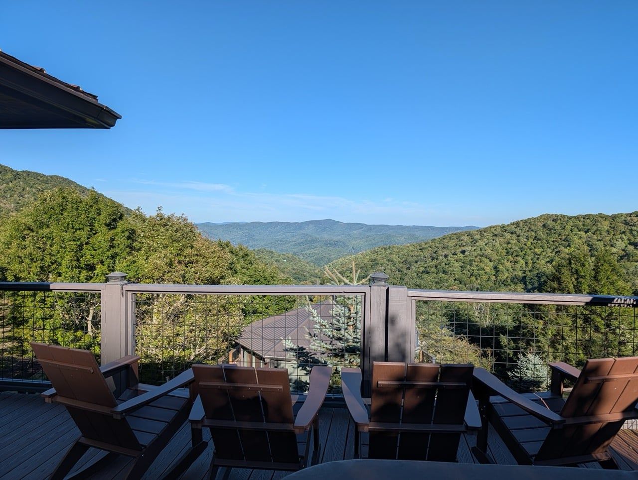 A deck with chairs overlooking a mountainous landscape.