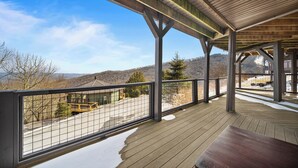 Eine überdachte Terrasse mit Blick auf eine gebirgige Landschaft.