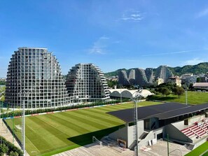A modern sports stadium with a large field and surrounding buildings. - Lakeside Luxe Apartment 2BR Prime Location (Tirana)