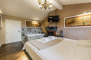 A bedroom with a large bed, a bathroom with a marble sink, a fireplace, and artwork on the walls. - Miracle No 8 Central Modern Duplex (Tirana)