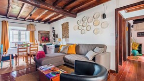 Una sala de estar acogedora con un sofá, una mesa de centro y un comedor con sillas y una mesa.