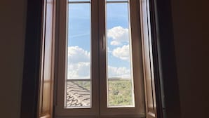 Ventana con tragaluz que muestra un cielo nublado y un paisaje lejano.
