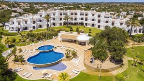 A resort with a large pool, multiple buildings, and a well-maintained lawn. - Clube Albufeira - 2BR Pool, Kids Club & Family Fun (Albufeira)