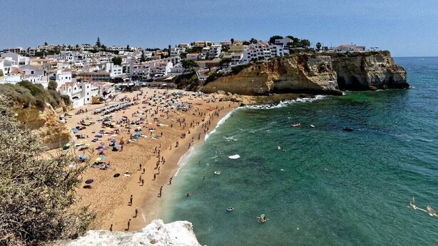Une ville côtière dotée d’une plage, d’eaux cristallines et de bâtiments construits sur une falaise.