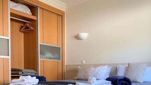 Une chambre à coucher avec un lit, une armoire et une table de chevet.
