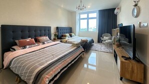 A modern hotel room with a large bed, a TV, a desk, and a window with a city view. - Kuching Holiday Family Home @ Riverine Kuching (Kuching)