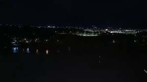 A nighttime view of a hotel with a swimming pool, a well-lit outdoor area, and a distant cityscape. - Kuching Holiday Family Home @ Riverine Kuching (Kuching)