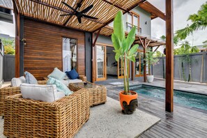 A modern outdoor living area with wicker furniture, a pool, and a wooden structure. - 2 Zen Bali Villa Canggu (Canggu)