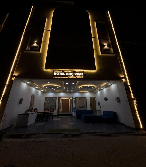 A hotel entrance with a modern design, featuring a reception desk, seating area, and a signboard. - Hotel Brij Vaas  (Vrindavan)