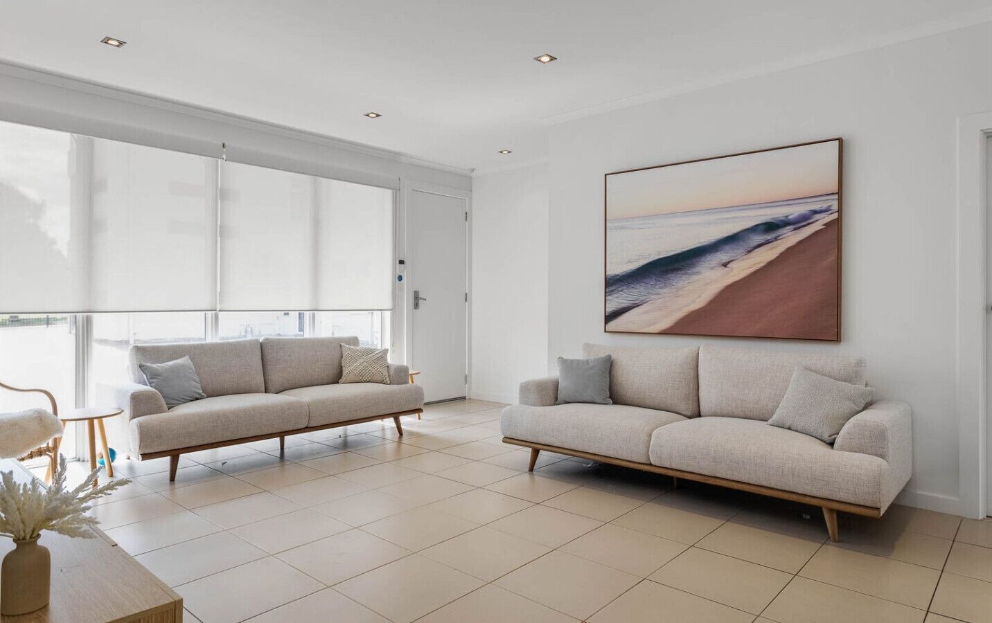 A modern living room with two sofas, a coffee table, and a large window.