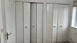 A room with white double doors, carpeted floor, and a window with blinds. - Romford Contractor / Family House (Romford)