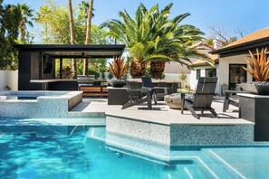 A modern outdoor pool area with a built-in bar, lounge chairs, and potted plants. - NEW 4BR Agave Moderne’ Estate | Pool, Hot Tub, Putting Green, Ping Pong & Fire Table (Scottsdale)