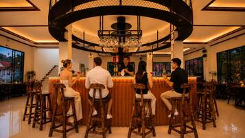 A bar area with a circular design, wooden stools, and a bartender.