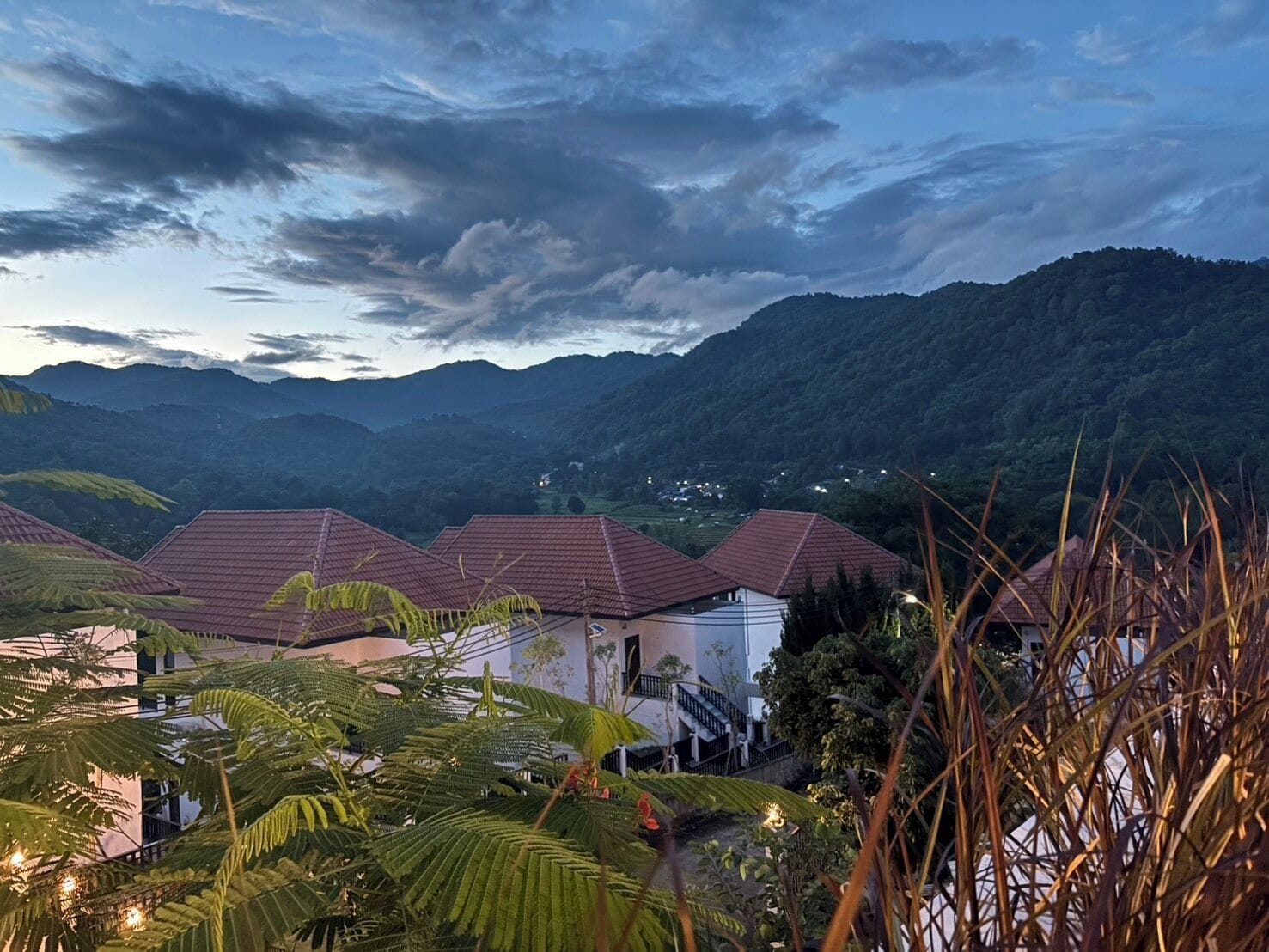 Un barrio residencial con casas, un sendero y montañas al fondo.