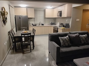 A modern kitchen with a dining area and a living room. - Resort Like Amenities - In the City #2 (Kingston)