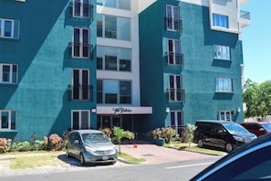 Ein mehrstöckiges Hotel mit einer türkisblauen Fassade, Balkonen und einem Schild mit der Aufschrift "The Delores".