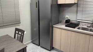 A compact kitchen with a built-in stainless steel refrigerator, a sink, and a countertop. - Resort Like Amenities - In the City #2 (Kingston)