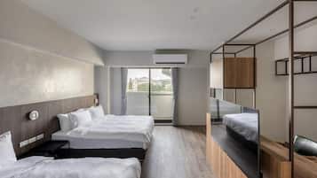 Quarto de hotel moderno com duas camas, uma janela grande e uma varanda.