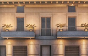 A building facade with three balconies, each with a small potted plant. There are two windows on each floor, and the building has a symmetrical design with a central door. - Beautiful apartment in Viareggio with WiFi (Viareggio)