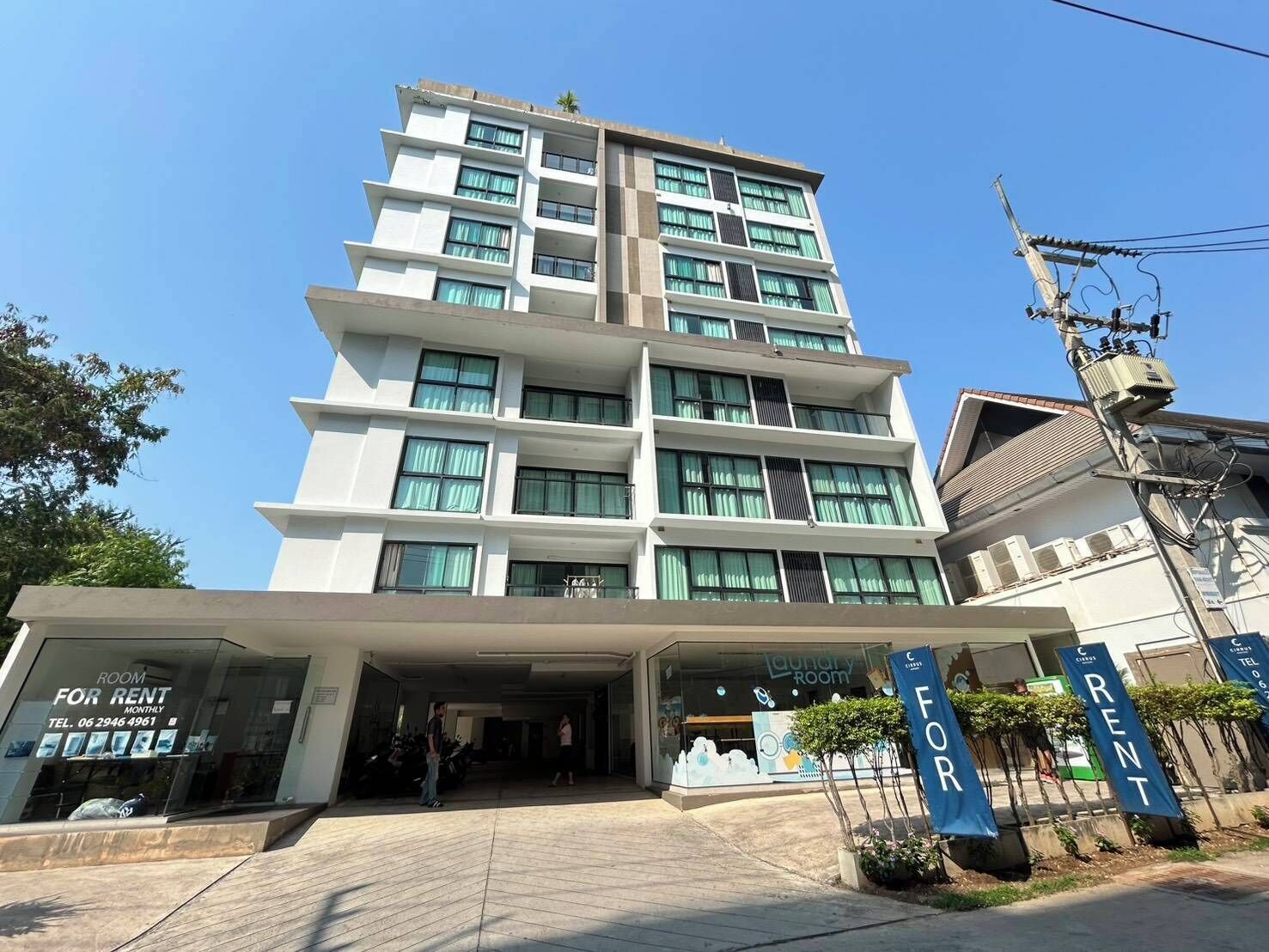A multi-story building with a modern design, featuring a prominent entrance with a glass facade and signage indicating it is a rental property.