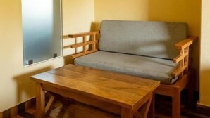 A room with a wooden bench, a small table, and a window. - Pinnacle Residences Pokhara (Pokhara)