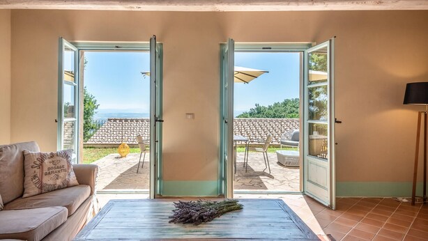A room with a sofa, a table with lavender, and a view of a patio with outdoor furniture. - 3 bedroom cozy apartment in Trequanda (Trequanda)
