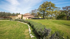 A large, multi-story building with a courtyard, surrounded by a well-maintained lawn and trees. - 3 bedroom cozy apartment in Trequanda (Trequanda)